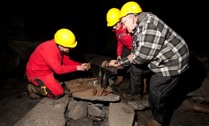 Visitors looking at old mining relics on a Corris Mine Explorers visit.